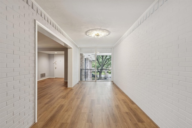 6325 Bandera Ave Unit C, Dallas, TX 75225 - empty room featuring light wood finished floors and brick wall