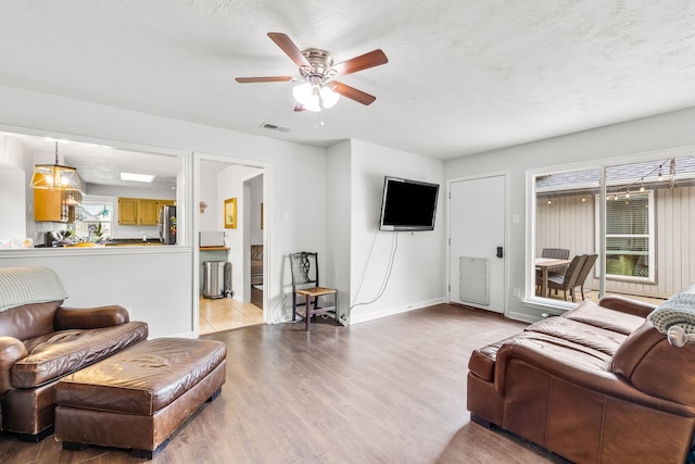 1638 Glencairn Ln, Lewisville, TX 75067 - living room featuring wood finished floors, a ceiling fan, and a textured ceiling