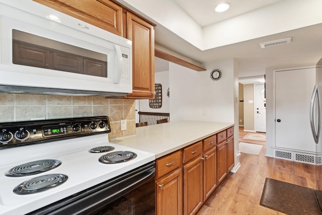 2318 Valleywood Dr, Carrollton, TX 75006 - kitchen featuring electric range, white microwave, and brown cabinets