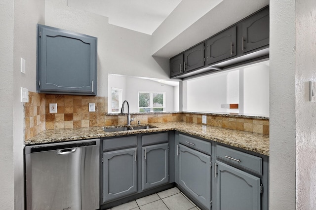 5644 Powers St, The Colony, TX 75056 - kitchen featuring stainless steel dishwasher, decorative backsplash, light stone counters, and gray cabinets