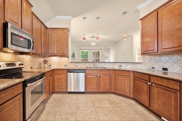 1224 Shelley Dr, Burleson, TX 76028 - kitchen with appliances with stainless steel finishes, brown cabinets, light stone countertops, ceiling fan, and decorative backsplash