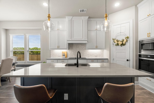 618 Sophia St, Midlothian, TX 76065 - kitchen featuring stainless steel appliances, tasteful backsplash, a breakfast bar, dark wood-style floors, and white cabinets