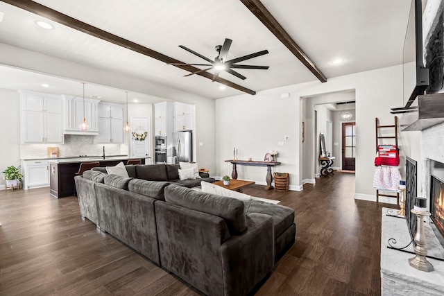 618 Sophia St, Midlothian, TX 76065 - living room featuring beamed ceiling, ceiling fan, dark wood-type flooring, a lit fireplace, and recessed lighting