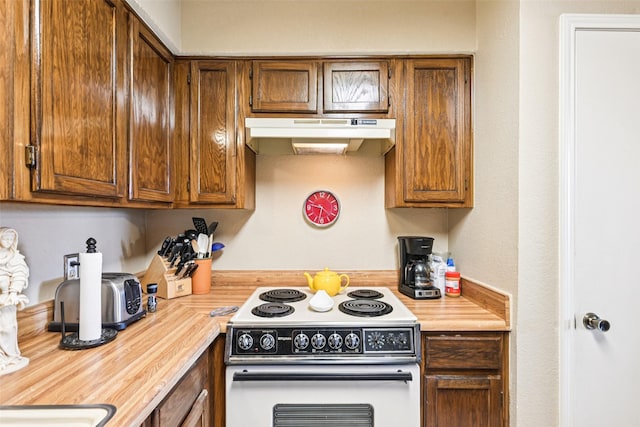406 Anice Ln, Euless, TX 76039 - kitchen with white electric stove, under cabinet range hood, light countertops, and brown cabinets