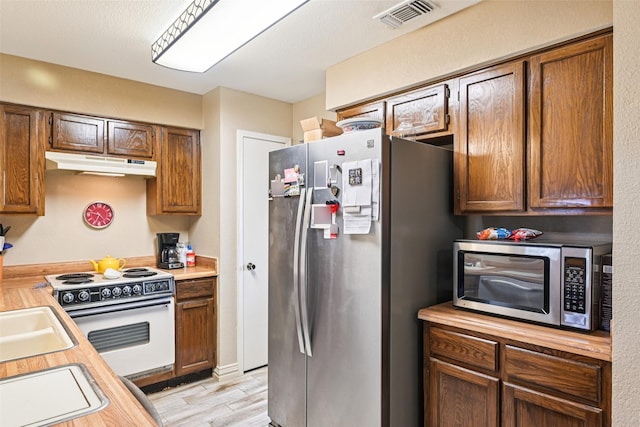 406 Anice Ln, Euless, TX 76039 - kitchen featuring stainless steel appliances, under cabinet range hood, and light wood-style floors