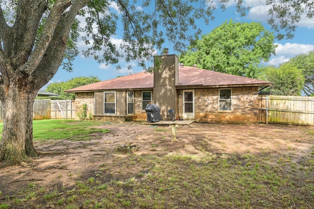 406 Anice Ln, Euless, TX 76039 - back of house featuring a chimney, brick siding, a fenced backyard, and a gate