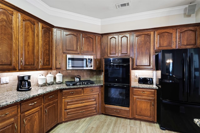 128 Country Club Dr, Heath, TX 75032 - kitchen with black appliances, light stone countertops, tasteful backsplash, crown molding, and light wood-style flooring