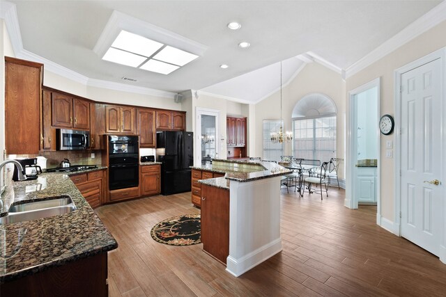 128 Country Club Dr, Heath, TX 75032 - kitchen with black appliances, a chandelier, ornamental molding, decorative backsplash, and vaulted ceiling