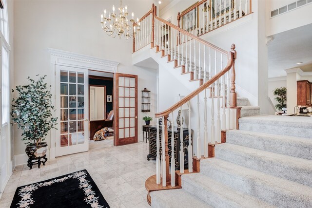128 Country Club Dr, Heath, TX 75032 - entryway featuring french doors, a towering ceiling, stairway, crown molding, and a chandelier