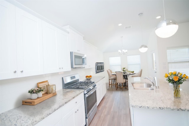 3913 Great Plains Way, Forney, TX 75126 - kitchen with stainless steel appliances, decorative backsplash, a chandelier, lofted ceiling, and white cabinets