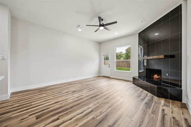 15578 Wrangler Dr, Frisco, TX 75035 - unfurnished living room featuring light wood-type flooring, a ceiling fan, a tile fireplace, and recessed lighting