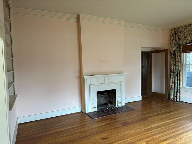 509 E Main St, Mexia, TX 76667 - unfurnished living room featuring wood finished floors, crown molding, and a tiled fireplace