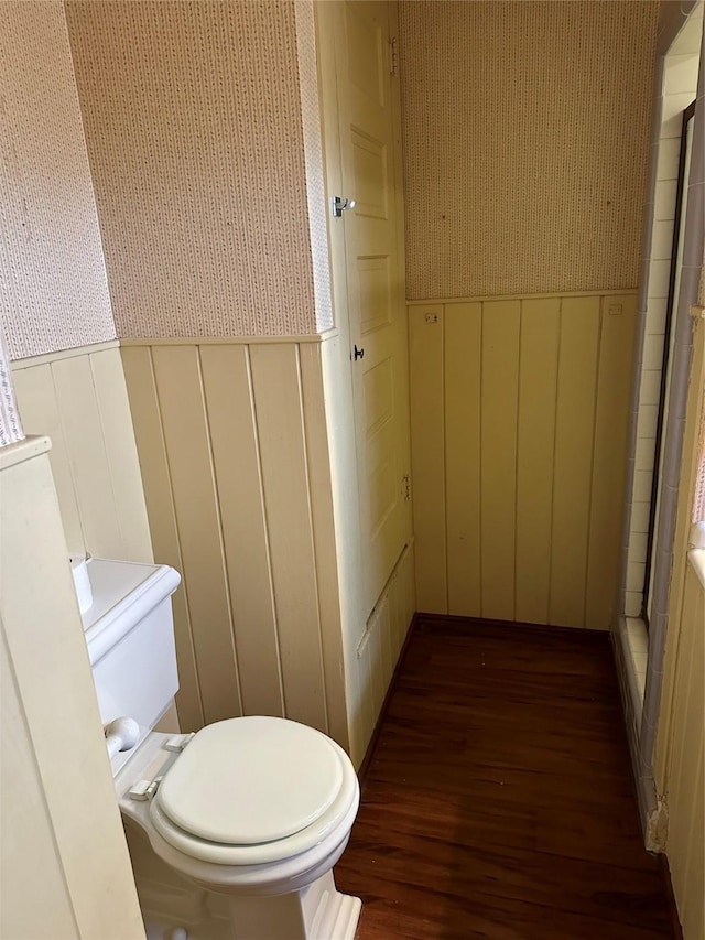 509 E Main St, Mexia, TX 76667 - bathroom with wood finished floors, a decorative wall, wallpapered walls, a shower with shower curtain, and a wainscoted wall