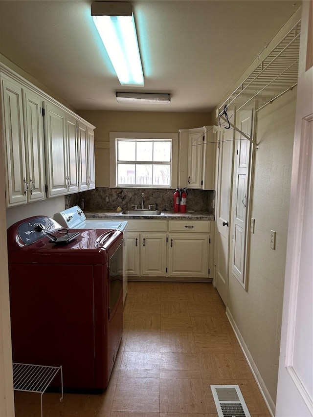 509 E Main St, Mexia, TX 76667 - laundry area featuring washing machine and clothes dryer, cabinet space, and light floors
