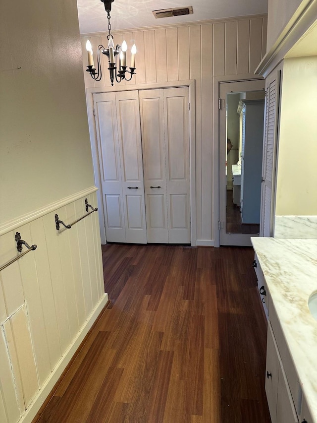 509 E Main St, Mexia, TX 76667 - unfurnished dining area with a chandelier, dark wood-style flooring, and a decorative wall