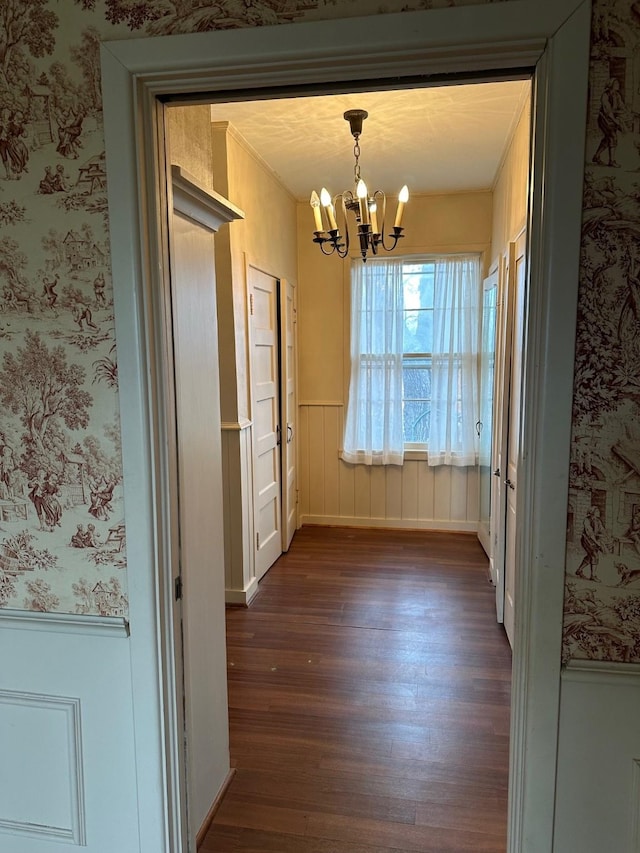 509 E Main St, Mexia, TX 76667 - unfurnished dining area with dark wood finished floors, a chandelier, wallpapered walls, and a wainscoted wall