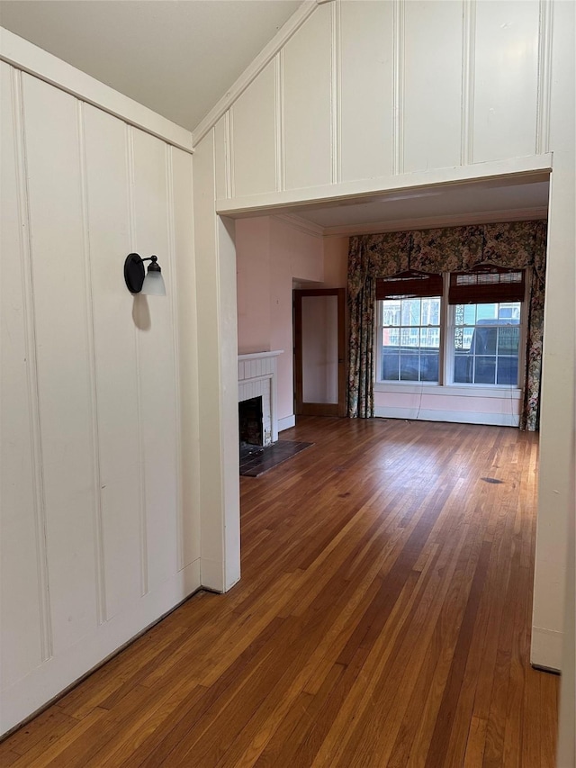 509 E Main St, Mexia, TX 76667 - unfurnished living room with a fireplace with flush hearth, a decorative wall, and wood-type flooring