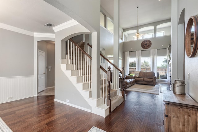 8508 Forsythia Dr, Mckinney, TX 75072 - stairs featuring wood finished floors, a ceiling fan, ornamental molding, arched walkways, and a wainscoted wall