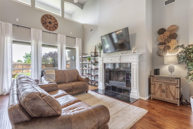 8508 Forsythia Dr, Mckinney, TX 75072 - living area featuring a high ceiling, wood finished floors, and a tiled fireplace