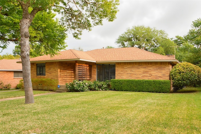 2542 Woodmere Dr, Dallas, TX 75233 - view of front of home featuring brick siding, a front yard, and a shingled roof