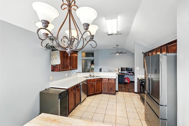 9212 Bedford Ln, Mckinney, TX 75071 - kitchen featuring stainless steel appliances, a chandelier, vaulted ceiling, ceiling fan, and a peninsula