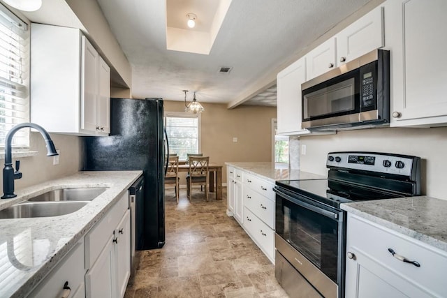 4737 Lawler Rd, Garland, TX 75042 - kitchen with stainless steel appliances, white cabinetry, healthy amount of natural light, and stone finish floors