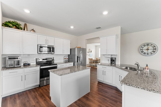 4917 Woodloch Dr, Princeton, TX 75407 - kitchen featuring stainless steel appliances, a peninsula, white cabinets, light stone counters, and recessed lighting