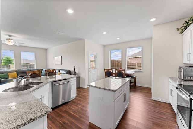 4917 Woodloch Dr, Princeton, TX 75407 - kitchen with appliances with stainless steel finishes, a kitchen island, dark wood-style floors, open floor plan, and a ceiling fan