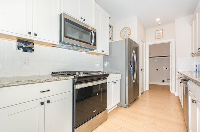 1103 Witherspoon Ln, Princeton, TX 75407 - kitchen with stainless steel appliances, white cabinetry, tasteful backsplash, light wood finished floors, and recessed lighting