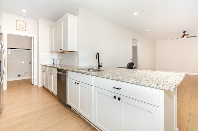 1103 Witherspoon Ln, Princeton, TX 75407 - kitchen with stainless steel dishwasher, a peninsula, white cabinetry, light wood-type flooring, and tasteful backsplash