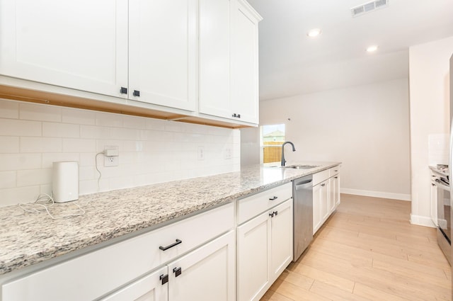 1103 Witherspoon Ln, Princeton, TX 75407 - kitchen featuring dishwasher, white cabinets, decorative backsplash, light wood finished floors, and light stone counters