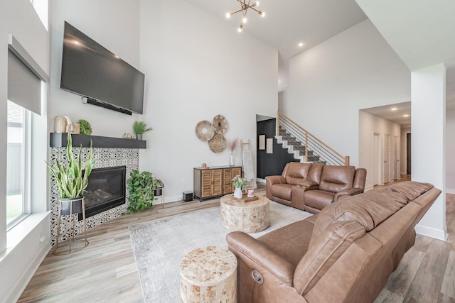 2420 Stella Ln, Northlake, TX 76247 - living area featuring healthy amount of natural light, a high ceiling, stairs, light wood-style floors, and a fireplace