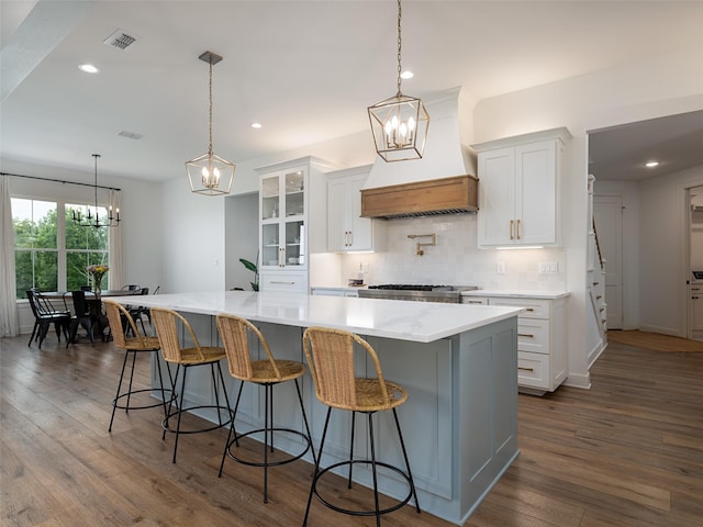 16652 Caeli Heights Ct, Winona, TX 75792 - kitchen featuring a chandelier, dark wood-type flooring, premium range hood, tasteful backsplash, and white cabinets
