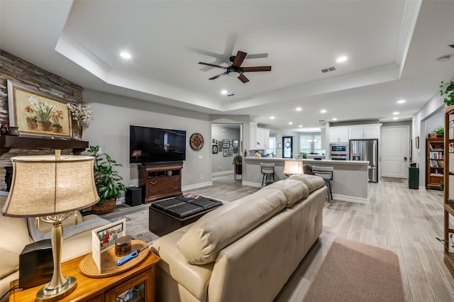 1116 Cornerstone Dr, Little Elm, TX 76227 - living area with a raised ceiling, light wood-style flooring, a ceiling fan, recessed lighting, and crown molding