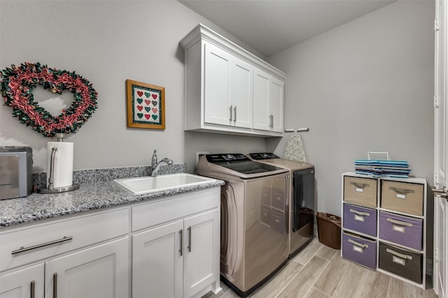 1116 Cornerstone Dr, Little Elm, TX 76227 - laundry room featuring washing machine and clothes dryer, cabinet space, and light wood finished floors