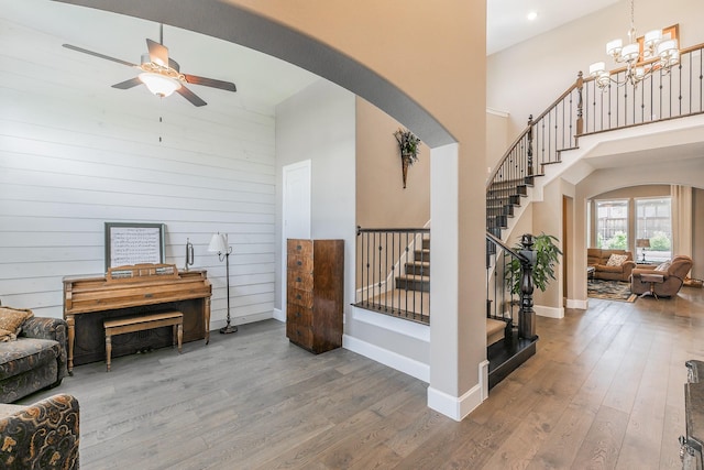 7925 Forest Lakes Dr, North Richland Hills, TX 76182 - living area featuring arched walkways, stairway, a towering ceiling, wood finished floors, and a ceiling fan