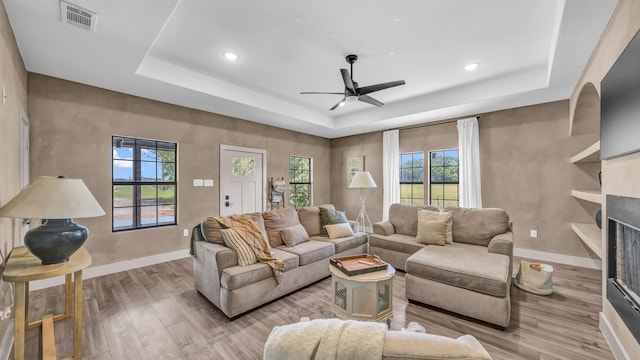 1381 County Road 1470, Chico, TX 76431 - living area with a tray ceiling, light wood finished floors, ceiling fan, recessed lighting, and a fireplace