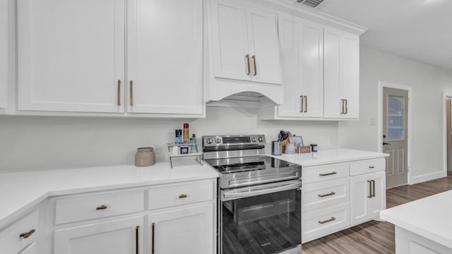 1381 County Road 1470, Chico, TX 76431 - kitchen featuring stainless steel electric range, light wood finished floors, light countertops, and white cabinetry