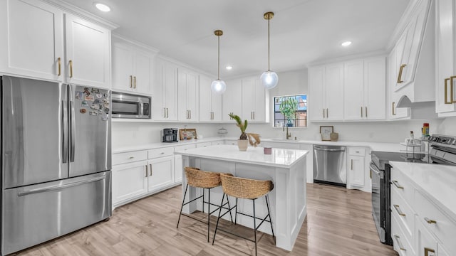 1381 County Road 1470, Chico, TX 76431 - kitchen with stainless steel appliances, a breakfast bar, white cabinetry, light wood-style floors, and recessed lighting