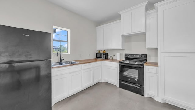 1381 County Road 1470, Chico, TX 76431 - kitchen with black appliances, concrete floors, white cabinets, and wood counters