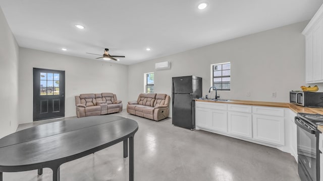 1381 County Road 1470, Chico, TX 76431 - kitchen featuring black appliances, wood counters, finished concrete floors, white cabinets, and recessed lighting
