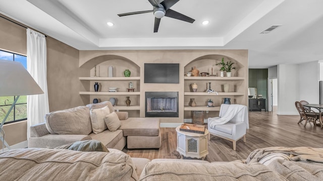 1381 County Road 1470, Chico, TX 76431 - living area featuring a ceiling fan, wood finished floors, built in shelves, a raised ceiling, and recessed lighting