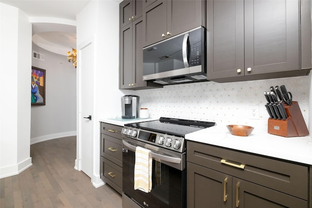 4333 Gilbert Ave Unit 330, Dallas, TX 75219 - kitchen featuring appliances with stainless steel finishes, backsplash, wood finished floors, and light countertops