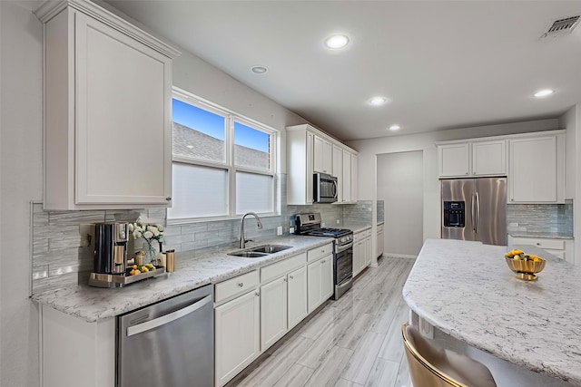 7616 Heritage Dr, Little Elm, TX 76227 - kitchen featuring stainless steel appliances, recessed lighting, tasteful backsplash, white cabinetry, and light wood-style floors