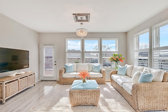 7616 Heritage Dr, Little Elm, TX 76227 - living area with healthy amount of natural light, wood finished floors, and a chandelier