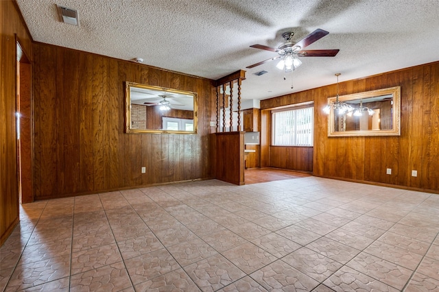 328 Bennett Cir, Desoto, TX 75115 - empty room featuring wooden walls, a ceiling fan, and a textured ceiling
