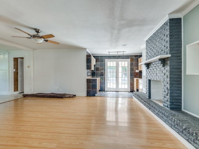 3836 Diamond Loch E, North Richland Hills, TX 76180 - unfurnished living room featuring a brick fireplace, light wood finished floors, a ceiling fan, and crown molding