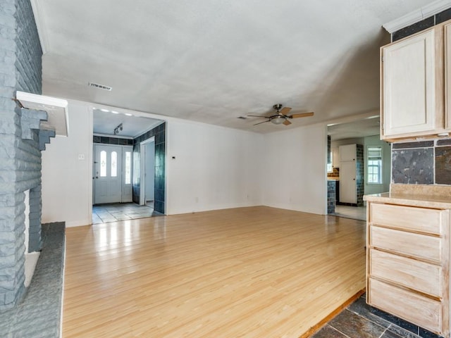 3836 Diamond Loch E, North Richland Hills, TX 76180 - unfurnished living room with a fireplace, light wood finished floors, a ceiling fan, and healthy amount of natural light