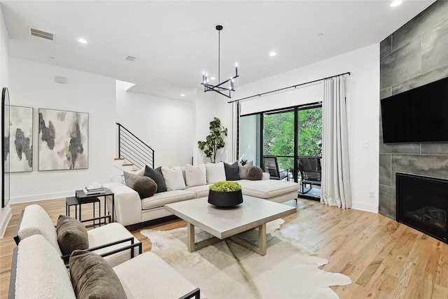 354 Foch St, Fort Worth, TX 76107 - living room featuring light wood-style floors, stairway, a chandelier, a fireplace, and recessed lighting
