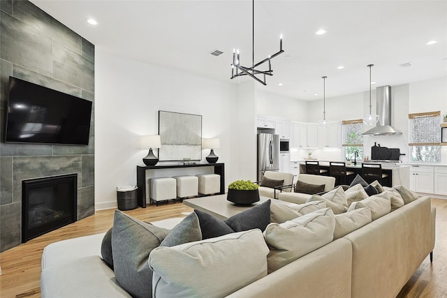 354 Foch St, Fort Worth, TX 76107 - living room featuring recessed lighting, light wood-style flooring, a chandelier, and a tile fireplace